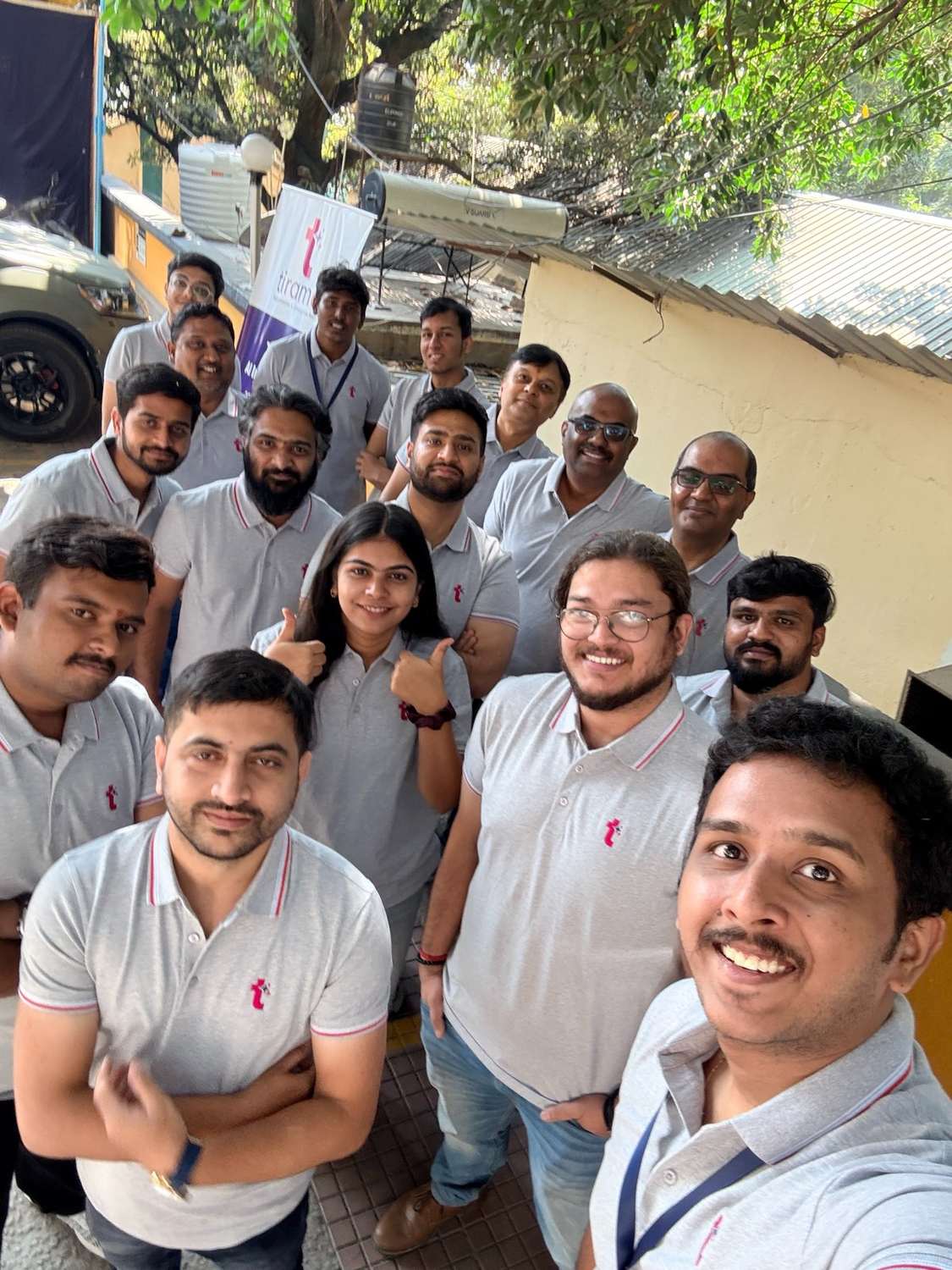 The tiramai team outside the new office in Bengaluru, under the company banner