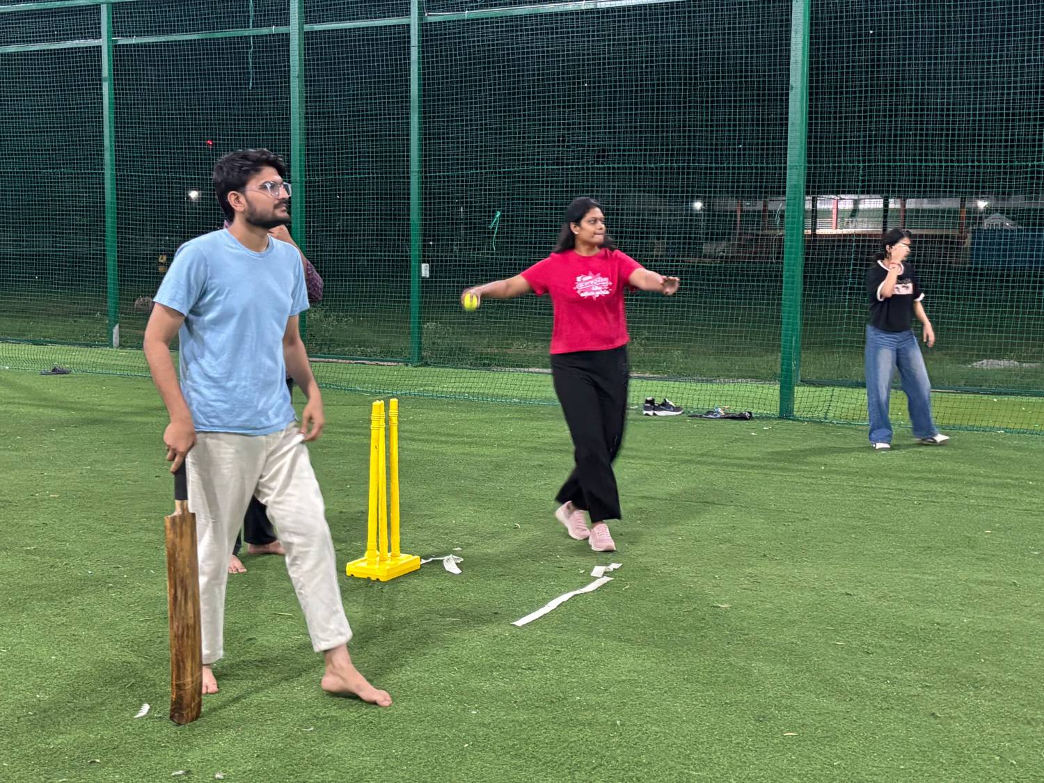 A tiramai team member bowling, with the batter and a fielder waiting