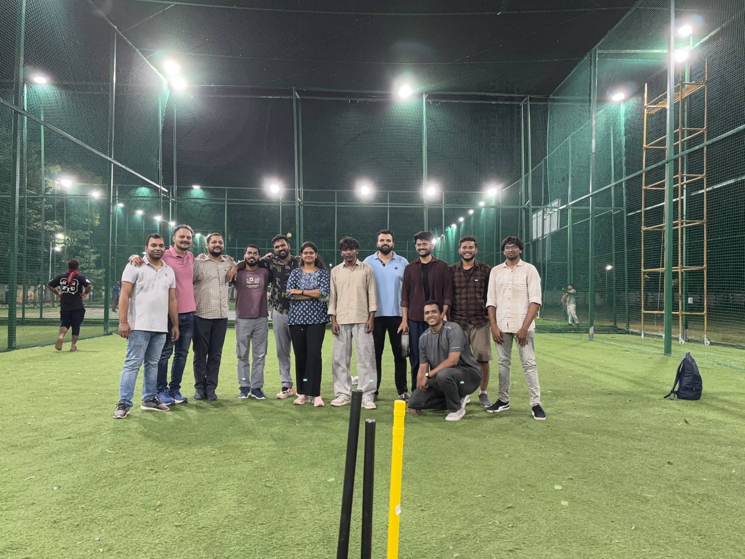 The tiramai team together on the cricket pitch under the floodlights